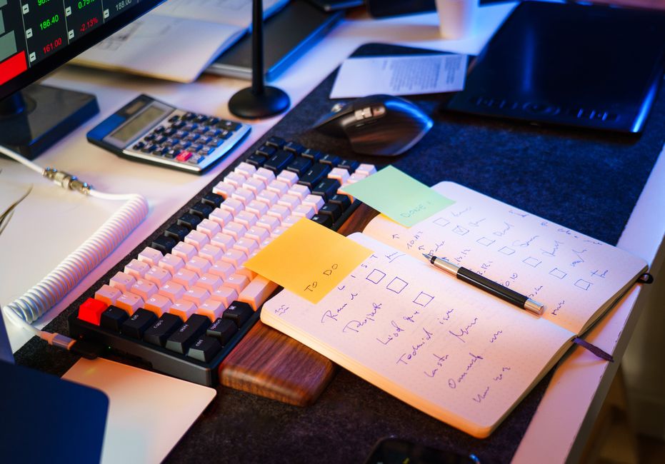 Modern office desk with keyboard, notebook, and checklist for productivity.
